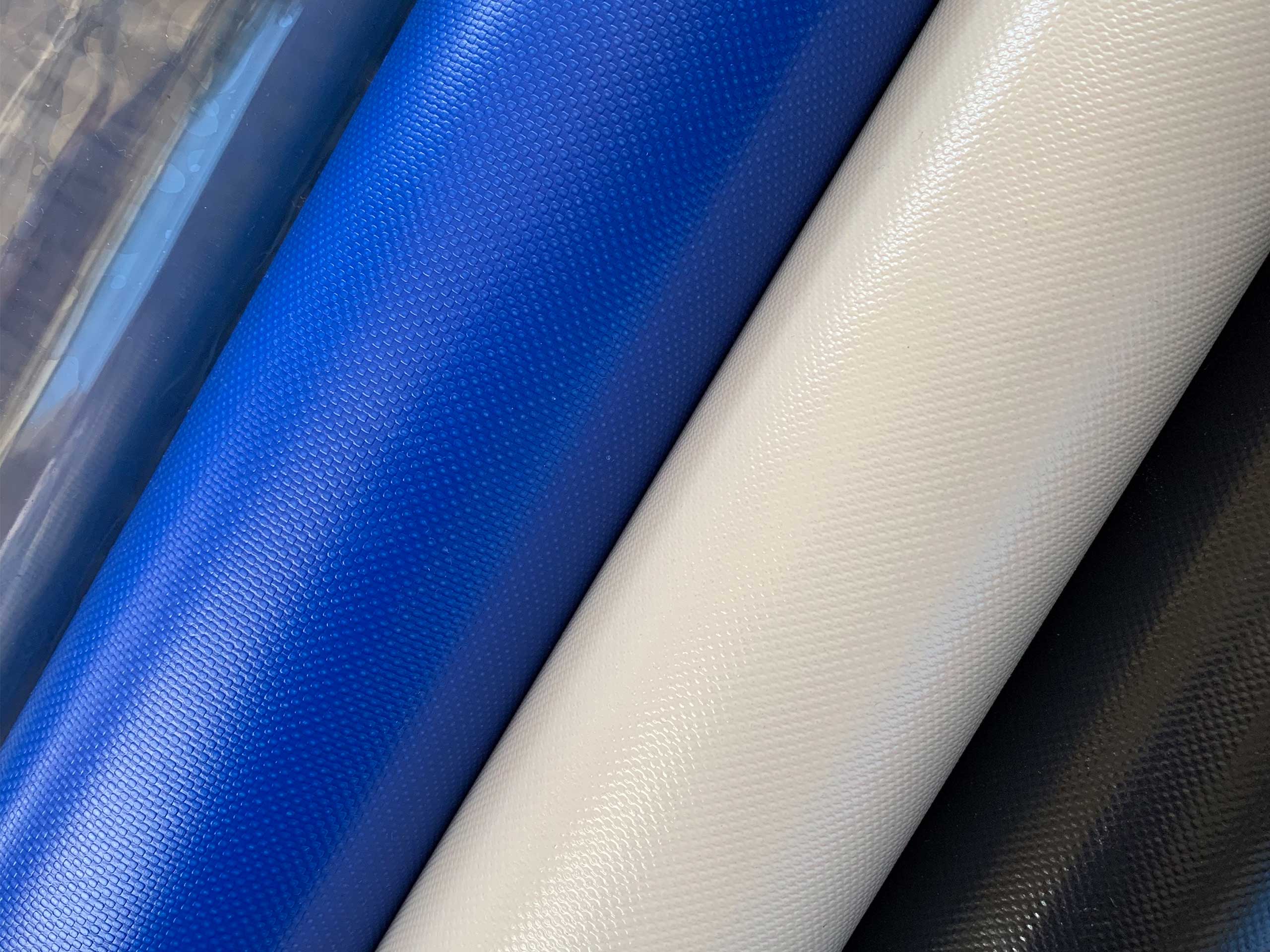 PVC-coated outdoor roller blind fabric rolls in blue, white and black